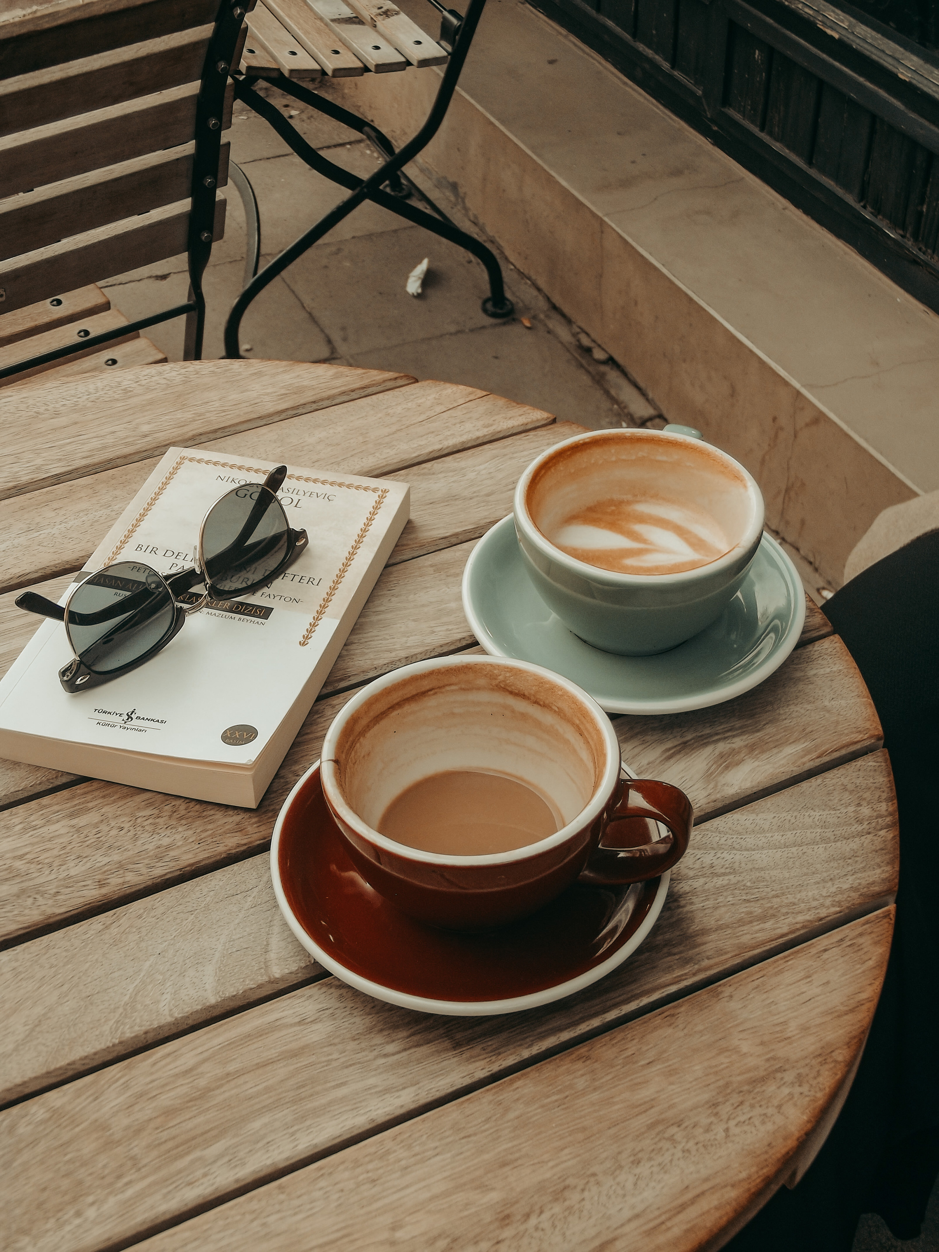 Cups of Coffee, Book and Sunglasses on Table